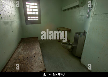 Intérieur de l'isolement cellulaire cell avec lit, bureau et toilettes dans la vieille prison. Banque D'Images