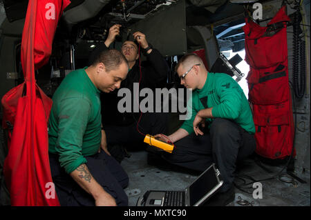 Des marins inspectent le câblage de démarrage moteur d'un hélicoptère MH-60S Sea Hawk affecté à l'escadron 7 de combat maritime à bord du porte-avions USS Dwight D. Eisenhower (CVN-69) le 6 décembre 2016. Le MH-60S, propulsé par deux turbomoteurs T700-GE-401C, offre des capacités utilitaires, de recherche et sauvetage à bord et de guerre anti-surface. Cette maintenance assure la préparation au vol, la sécurité et l’efficacité opérationnelle lors du déploiement du Eisenhower Carrier Strike Group en Méditerranée. Banque D'Images