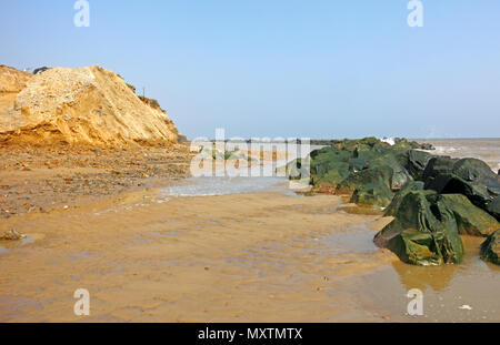 Une vue de la plage entre les rochers et falaises d'érosion des défenses de la mer sur la côte de Norfolk à Happisburgh, Norfolk, Angleterre, Royaume-Uni, Europe. Banque D'Images