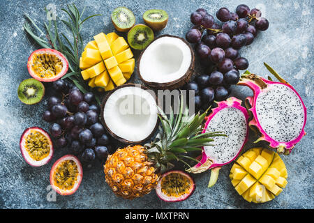 Assortiment de fruits tropicaux exotiques, vue du dessus. La passion, dragonfruit, mangue, ananas, kiwi, raisins et noix de coco. Fond d'aliments frais. En bonne santé Banque D'Images