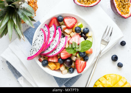 Salade de fruits tropicaux avec fruit du dragon et la mangue dans un bol. Salade de fruits exotiques aux couleurs vives sur fond blanc, dessus de table view Banque D'Images