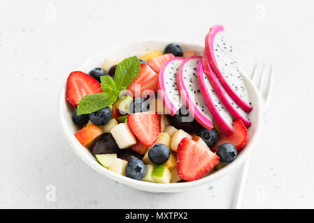 Thai salade de fruits avec de la mangue et de pitaya blanc dans un bol, vue rapprochée. Concept de l'été, les vacances, l'alimentation végétarienne et végétalienne, la saine alimentation et la santé. Banque D'Images