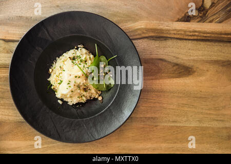 Vue de dessus au risotto aux céleri levisticum gem monter et sur une composition de tables en bois Banque D'Images