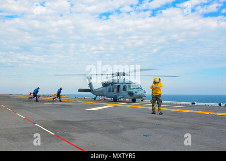 Un hélicoptère MH-60S KnightHawk du Helicopter Sea combat Squadron 28 atterrit sur le pont d'envol du navire d'assaut amphibie USS Iwo Jima (LHD 7) le 5 décembre 2016. Le navire effectue des exercices de certification Mobility-Engineering et Mobility-Seaman dans le cadre de son processus de qualification préalable au déploiement. L'opération démontre l'intégration de l'aviation navale avec les navires amphibies, la manutention des hélicoptères, les opérations de pont et la compétence de l'équipage pour la préparation opérationnelle. Banque D'Images