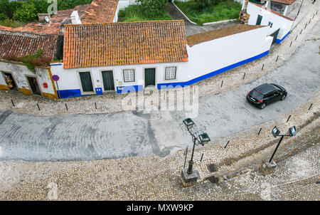 Voiture roule le long d'une rue à Obidos, Portugal juste à l'extérieur du mur. Banque D'Images