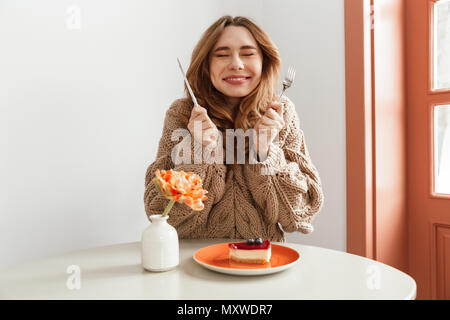 Portrait d'une femme dans l'homme excité prêt à manger gâteau au fromage sur une plaque à la table Banque D'Images