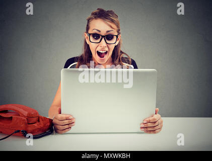 Jeune femme expressive dans les verres et de crier à cause de nouvelles bouleversantes Banque D'Images