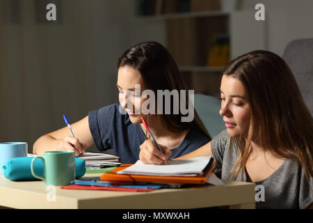 Deux élèves à faire leurs devoirs ensemble dans la nuit à la maison Banque D'Images