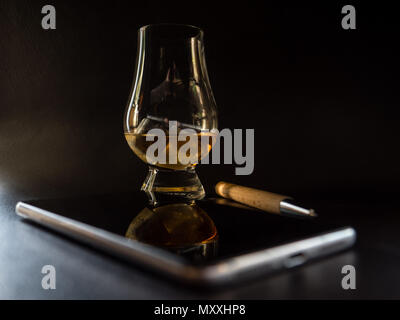 Stylo en bois avec verre de whisky et le smartphone à partir de ci-dessus, surface sombre Banque D'Images