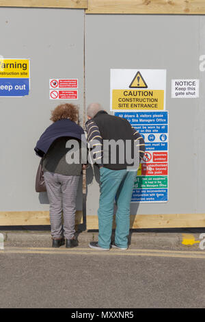 Porthcawl, Mid Glamorgan, Pays de Galles, Royaume-Uni. 14 avril 2018. UK. Météo britannique. Signes de santé et de sécurité sur le site de construction, les piétons à la recherche dans le b Banque D'Images