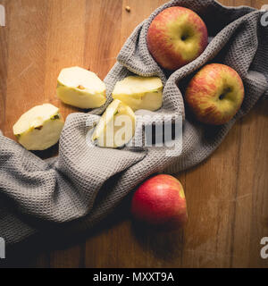 Vue de dessus de pommes sur une planche en bois avec un chiffon de cuisine gris. Format carré. Banque D'Images