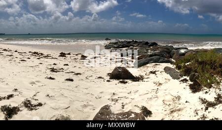 Panorama pittoresque de l'idyllique plage de Welches, Oistins La Barbade (Caraïbes) avec de grandes pierres noires / les roches, le sable blanc et une mer turquoise Banque D'Images