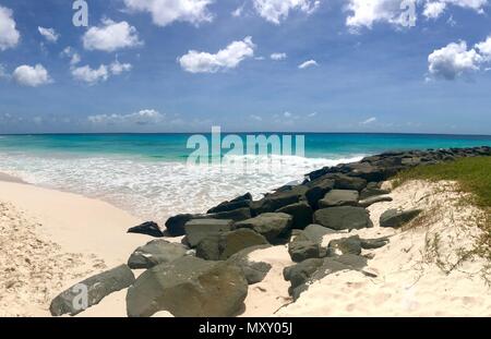 Panorama pittoresque de l'idyllique plage de Welches, Oistins La Barbade (Caraïbes) avec de grandes pierres noires / les roches, le sable blanc et une mer turquoise Banque D'Images