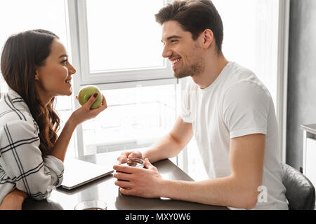 Image homme et femme à l'un l'autre tout en restant assis à table à l'intérieur près grande fenêtre Banque D'Images