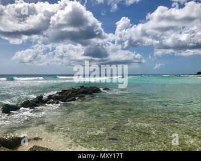 Plage idyllique idyllique intacte, à Oistins, Barbade (île des Caraïbes) avec des pierres, du sable et des vagues Banque D'Images