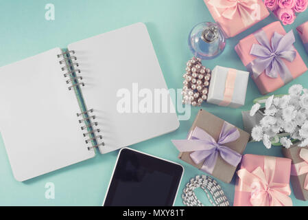 Arrière-plan de fête cadeau poster satin bouquet de fleurs perle bijoux smartphone tablette portable fond bleu. Vue d'en haut copie espace f Banque D'Images