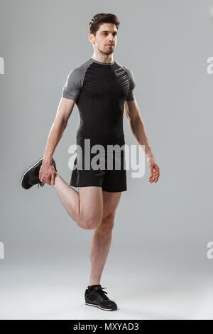 Portrait d'un jeune sportif en phase de préchauffage sur fond gris isolé Banque D'Images