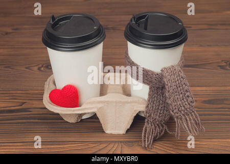 Deux tasses de café avec coeur en tricot et foulard sur fond de bois Banque D'Images