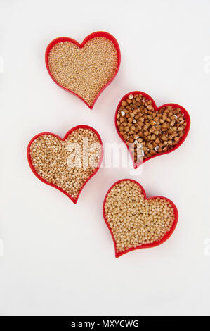 Cœurs remplis de l'amarante, le millet, le sarrasin et le quinoa isolated on white Banque D'Images