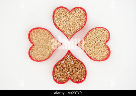 Quatre cœurs remplis de graines de super l'amarante, le millet, le sarrasin et le quinoa isolated on white Banque D'Images