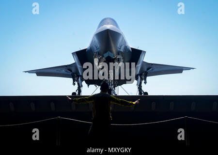 180602-N-A135-054 (OCÉAN PACIFIQUE) 2 juin 2018 - Aviation maître de Manœuvre (manutention) 1re classe Glenn Catbagan des signaux à main qu'un F-35B Lightning II, attaché à la "Avengers" de Marine Fighter Attack Squadron (VMFA) 211, monte sur un avion à bord de l'élévateur de classe Wasp navire d'assaut amphibie USS Essex (DG 2) au cours de l'exercice de l'unité de formation composite (COMPTUEX). COMPTUEX est le dernier exercice de pré-déploiement qui certifie l'Essex combiné Groupe amphibie (ARG) et 13e Marine Expeditionary Unit (MEU) capacité à mener des opérations militaires en mer et à terre au cours d'un projet Banque D'Images