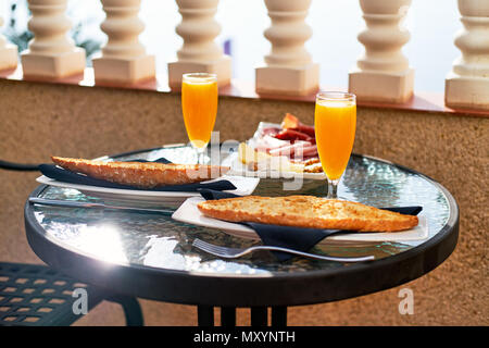 Restaurant en plein air. Réglage de la table avec petit déjeuner classique. Jus d'Orange et d'un toast Banque D'Images