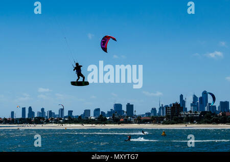 Kite surfeurs en action à Port Phillip Bay près de St Kilda avec ville de Melbourne dans la distance, Victoria, Australie Banque D'Images