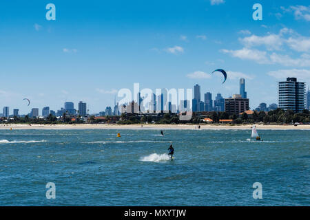 Kite surfer l'atterrissage sur les eaux de Port Phillip Bay près de St Kilda à Melbourne City Skyline dans la distance, Victoria, Australie Banque D'Images