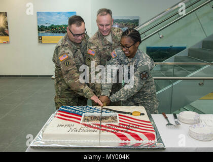 Selon la tradition, Brig. Le général Phillip S. Jolly, l'Europe de l'armée américaine le général commandant adjoint de mobilisation et d'affaires de réserve, coupe le gâteau avec le plus jeune et le plus ancien membre de l'organisation au cours de la 380e anniversaire de la Garde nationale sur l'Argile Kaserne, Wiesbaden, Allemagne, le 13 décembre 2016. Sur la photo, le sergent-chef. Keith Knudson, déploiement outre-mer sous-programme de formation général ; jovial ; et le Sgt. Helen Buford, analyste du renseignement de l'Armée américaine à Wiesbaden de garnison. (Photo crédit : Susanne Goebel, spécialiste de l'information visuelle) Banque D'Images