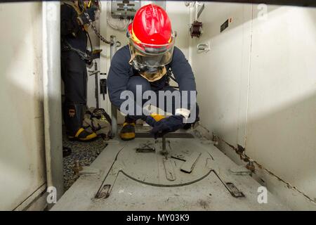 161220-N-HB733-085 OCÉAN ATLANTIQUE (déc. 20, 2016) Seaman Khalid Harvey ouvre une trappe au cours d'un exercice général quarts à bord du destroyer lance-missiles USS Cole (DDG 67). Cole, attribué à, commandant de la Task Force 65, procède à un déploiement régulièrement prévues à l'appui d'opérations de sécurité maritime et les efforts de coopération en matière de sécurité dans le théâtre aux États-Unis 6e flotte zone d'opérations.(U.S. Photo de la marine par le maître de 3e classe Brianna K. Green/libérés) Banque D'Images