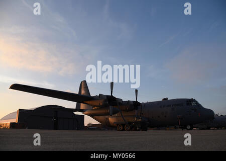 Le soleil se lève sur la piste à la 179e Airlift Wing, Mansfield, Ohio, jetant son incandescence du matin sur le C-130H Hercules le 28 décembre 2016. La 179e Escadre de transport aérien est toujours pour mission d'être le premier choix pour répondre à la communauté, de l'État fédéral et les missions d'une équipe de confiance d'aviateurs hautement qualifiés. (U.S. Photo de la Garde nationale aérienne Airman Megan Shepherd/libérés) Banque D'Images