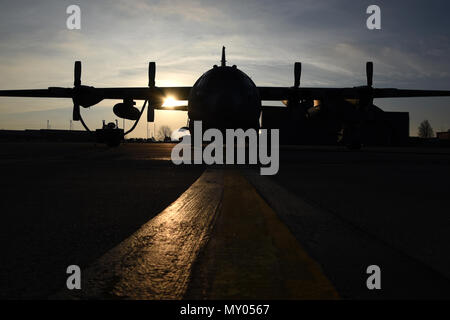 Le soleil se lève sur la piste à la 179e Airlift Wing, Mansfield, Ohio, jetant son incandescence du matin sur le C-130H Hercules le 28 décembre 2016. La 179e Escadre de transport aérien est toujours pour mission d'être le premier choix pour répondre à la communauté, de l'État fédéral et les missions d'une équipe de confiance d'aviateurs hautement qualifiés. (U.S. Photo de la Garde nationale aérienne Airman Megan Shepherd/libérés) Banque D'Images