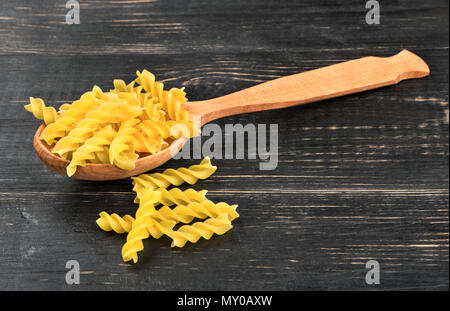 Cuillère à pâtes Fusilli sur fond de bois Banque D'Images