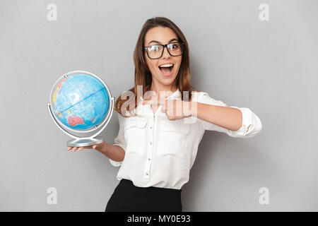 Portrait d'une jeune femme d'affaires excité face au globe de la terre isolé sur fond blanc Banque D'Images