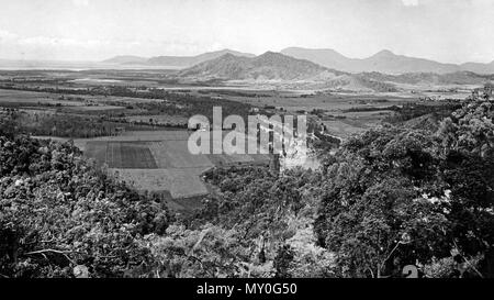 Barron Valley montrant fermes de canne à sucre, Cairns, c 1935. Cairns Post 8 novembre 1935 récolte de sucre 41713552 ) si les douches au cours des derniers jours ont affecté les opérations dans le canefields la récolte de sucre s'effectue rapidement dans la zone de Hambledon.. Un accident dans l'usine causé quelques jours de retard dans l'usine de Hambledon la semaine dernière, mais il est prévu que la saison de broyage prendra fin en environ une quinzaine de jours. Banque D'Images