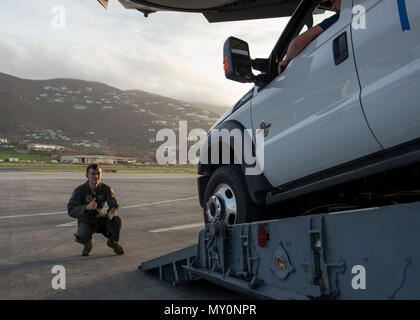 Navigant de première classe Logan Smith, Escadron de transport aérien 3d'arrimeur, martiale d'une Ford F-450 pick-up comme il appuie dans un C-17 Globemaster III, 24 septembre 2017, à l'Aéroport international Cyril E. King sur St Thomas, Îles Vierges des États-Unis. La camionnette soutenue dans l'avion afin de décharger une agence fédérale de gestion des urgences à la tour de radio mobile terrestre. (U.S. Photo de l'Armée de l'air par la Haute Airman Zachary Cacicia) Banque D'Images