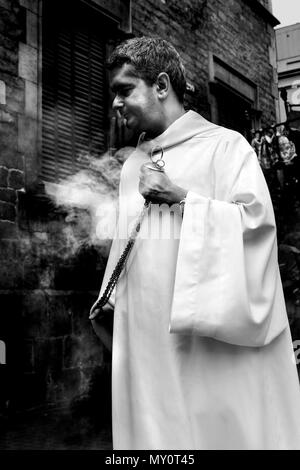 Prêtre catholique, purifier l'air au cours d'une cérémonie de communion, Barcelone, Espagne. Banque D'Images