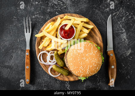 Burger de boeuf, frites, les cornichons, l'oignon et le ketchup. Vue de dessus de table. Concept de restauration rapide Banque D'Images