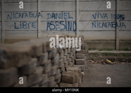 04 juin 2018, le Nicaragua, Masaya : un mur indique 'Nicaragua libre. Daniel, Asesino. Viva 100 % Nicaragua' (lit. de Nicaragua, Daniel, meurtrier, vivent à 100 % Nicaragua) à côté d'une barricade. Pour la plupart, Masaya est contrôlée par les opposants au gouvernement qui ont érigé des barricades et refuser l'accès à la police. Des hommes armés à capuchon d'assaut la ville le dimanche soir (heure locale), selon des militants des droits de l'homme. Photo : Carlos Herrera/dpa Banque D'Images