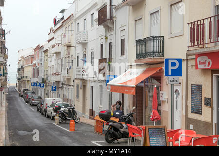 Rue typique menant à la plage de Nazaré, Portugal. Parkings marqués sont réservés aux véhicules individuels identifiés par des plaques. Banque D'Images