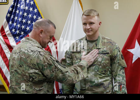 Le brig. Le général Robert D. Harter, 316E (commande de soutien général commandant du Corps expéditionnaire), place le grade de premier lieutenant sur Christopher Mann au cours d'une cérémonie de promotion au Camp Arifjan, au Koweït, le 31 décembre 2016. (U.S. Photo de l'armée par le Major Jules Penn) Banque D'Images