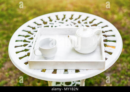Table basse avec plateau pot et verre sur plateau en bois dans le jardin. Banque D'Images