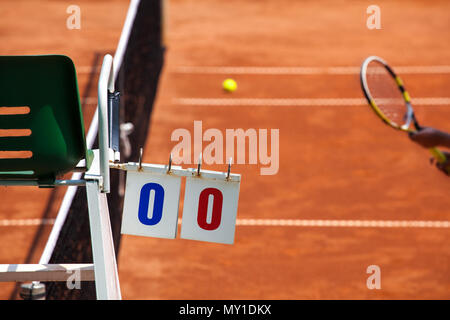 Tennis player juge-arbitre chaise avec affichage et de racket sur un cour d'argile dans le début du jeu. Banque D'Images