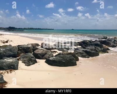 Panorama pittoresque de l'idyllique plage de Welches, Oistins La Barbade (Caraïbes) avec de grandes pierres noires / les roches, le sable blanc et une mer turquoise Banque D'Images