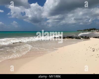 Panorama pittoresque de l'idyllique plage de Welches, Oistins La Barbade (Caraïbes) avec de grandes pierres noires / les roches, le sable blanc et une mer turquoise Banque D'Images