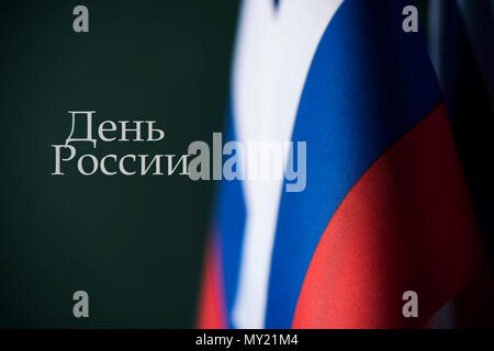 Libre de certains drapeaux russe et la Russie texte jour écrits en russe contre un fond vert sombre Banque D'Images