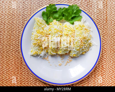 Dessert traditionnel thaïlandais, Thai sweet dessert, riz haricots mungo-crêpe et sésame blanc,de noix de coco en plaque blanche sur fond de table en bois. Banque D'Images