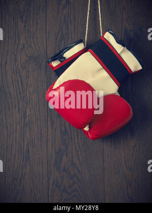 Gants de boxe rouge sur un mur en bois rustique, des sports ou de l'affirmation de concept Banque D'Images