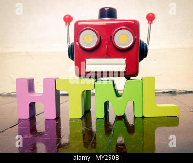 Lettres en bois wit HTML et un robot rouge têtes parlantes sur un sol en bois avec réflexion Banque D'Images