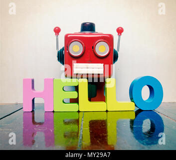 Talking head rouge dit bonjour sur plancher en bois avec réflexion Banque D'Images